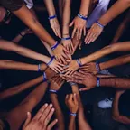 Mãos unidas ao centro em grupo